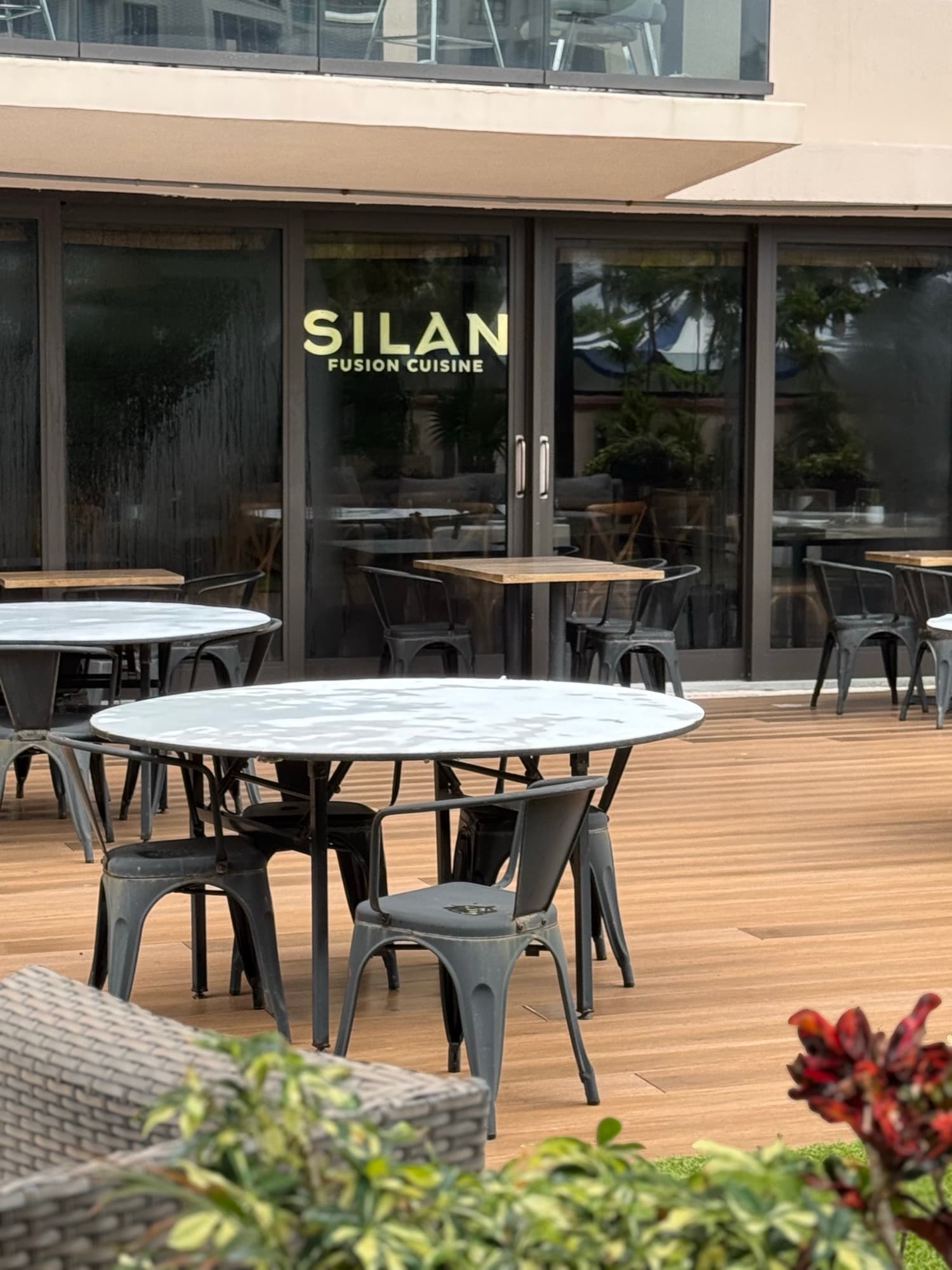The Silan terrace in daylight, tables set outside the restaurant entrance